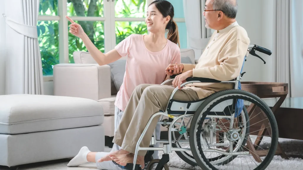Wheelchair in a home environment next to a patient's bed.